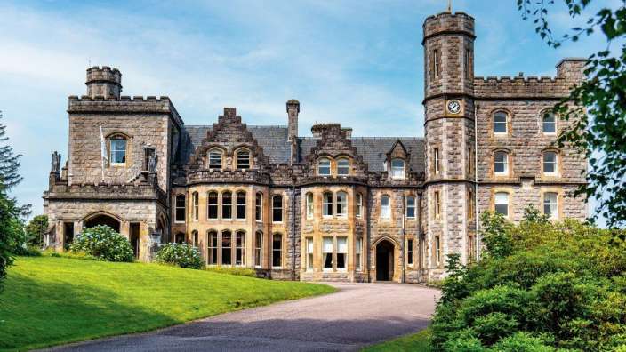 Ein großes Steingebäude mit einem Turm und einer Uhr darauf