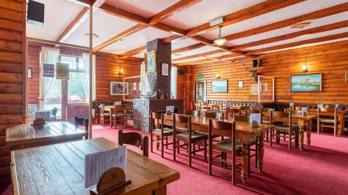 Ein Restaurant mit Holzböden und Tischen und Stühlen