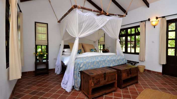 Ein Schlafzimmer mit einem Himmelbett und zwei Nachttischen