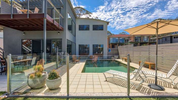 Ein großes Haus mit einem Pool und einem Sonnenschirm