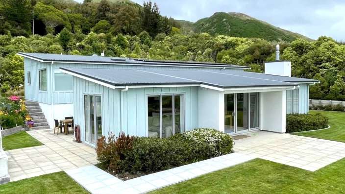 Ein blaues Haus mit einem schwarzen Dach und vielen Fenstern