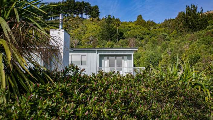 Ein weißes Haus auf einem Hügel umgeben von Bäumen