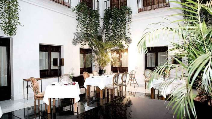 Ein Esszimmer mit weißen Tischen und Stühlen