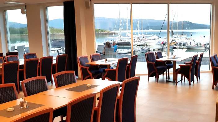 Tische und Stühle in einem Restaurant mit Blick auf den Hafen