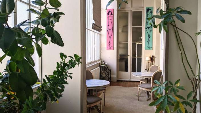 Ein Flur mit Tischen und Stühlen und einem Gemälde an der Wand