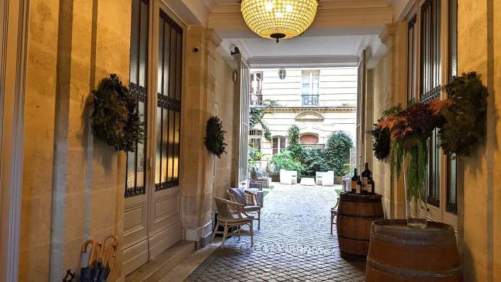 Ein Flur mit einem Kronleuchter und einem Weinfass