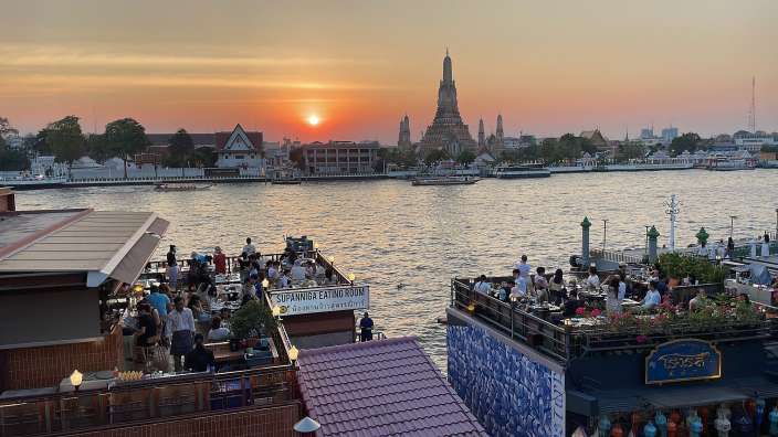 Eine Gruppe von Menschen sitzt auf einem Boot mit einem Schild darauf, das sagt " supander eating room "