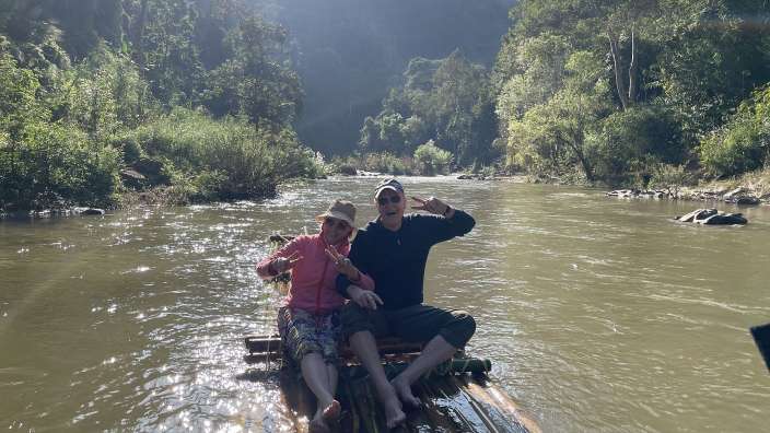Ein Mann und eine Frau sitzen auf einem Floß in einem Fluss