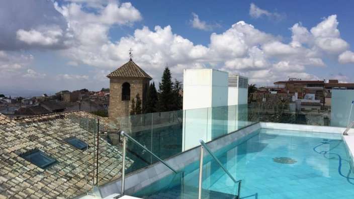 Ein Pool auf dem Dach eines Gebäudes mit Blick auf eine Stadt
