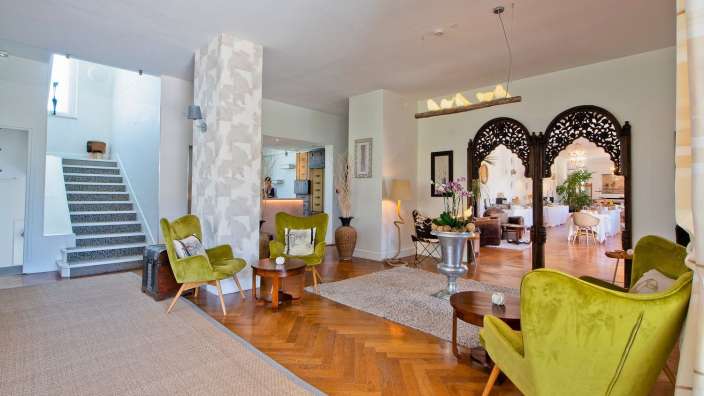 Ein Wohnzimmer mit grünen Stühlen und Treppen