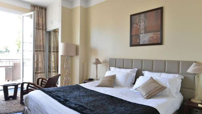 Ein Hotelzimmer mit einem großen Bett und einem Gemälde an der Wand