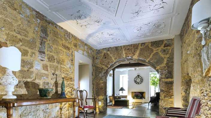 Ein Flur mit Steinwänden und einer Uhr an der Decke