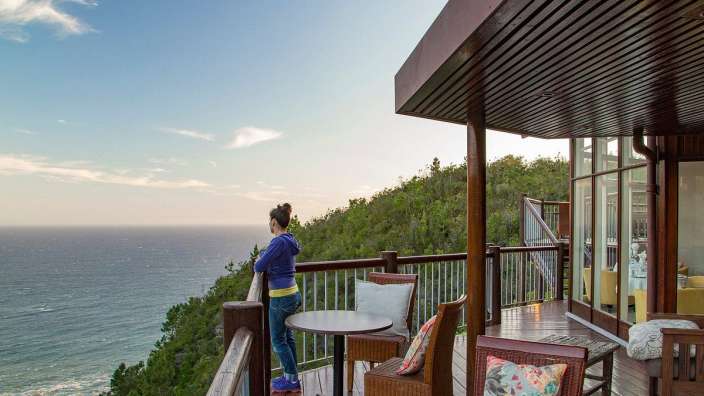 Eine Frau steht auf einem Deck mit Blick auf das Meer