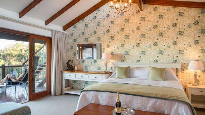 Ein Schlafzimmer mit einem Bett und einem Tisch mit einer Flasche Champagner darauf