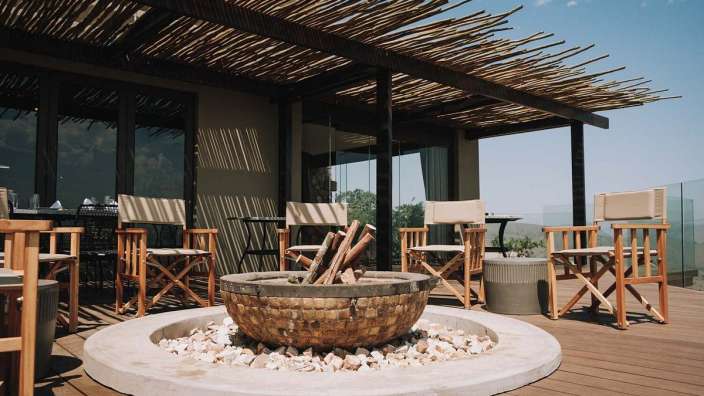 Eine Feuerstelle auf einem Holzdeck mit Stühlen