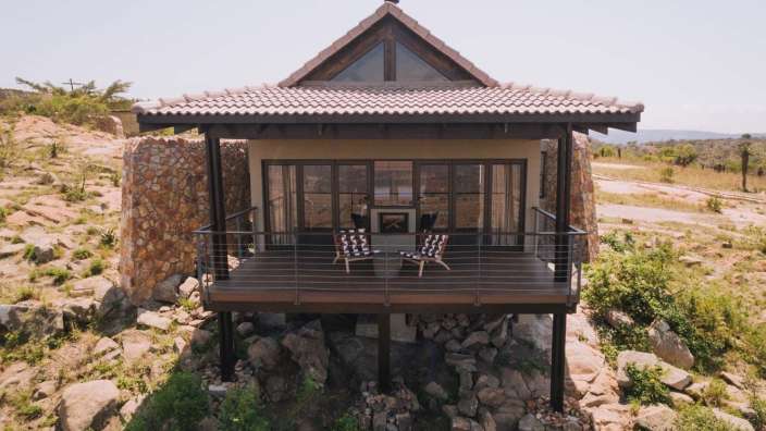 Ein kleines Haus auf einem Felsen mit einem Balkon