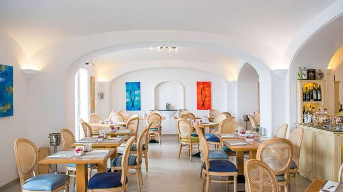 Ein Esszimmer mit vielen Tischen und Stühlen