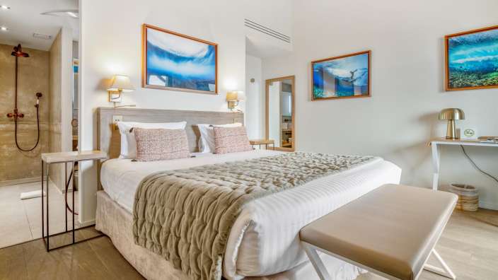 Ein Schlafzimmer mit einem Bett und zwei Bildern an der Wand