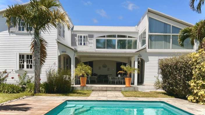 Ein großes weißes Haus mit einem Pool davor