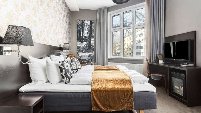 Ein Hotelzimmer mit einem Bett und einem Fernseher