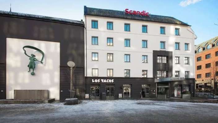 Ein großes weißes und schwarzes Gebäude mit einer Statue davor .
