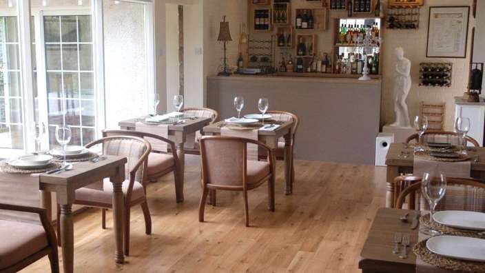 Ein Esszimmer mit Tischen und Stühlen und einer Bar