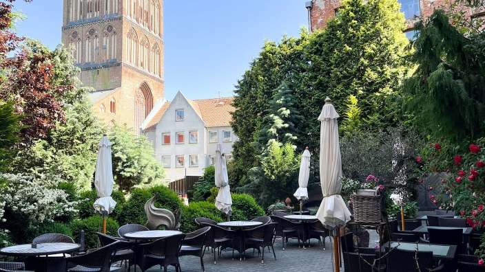 Tische und Stühle in einem Garten mit einem Turm im Hintergrund