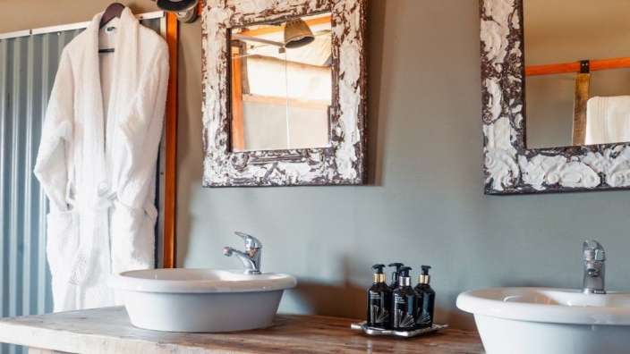 Ein Badezimmer mit zwei Waschbecken und zwei Spiegeln