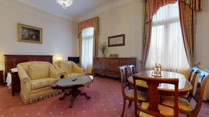 Ein Wohnzimmer mit einem Tisch und Stühlen und einem Gemälde an der Wand