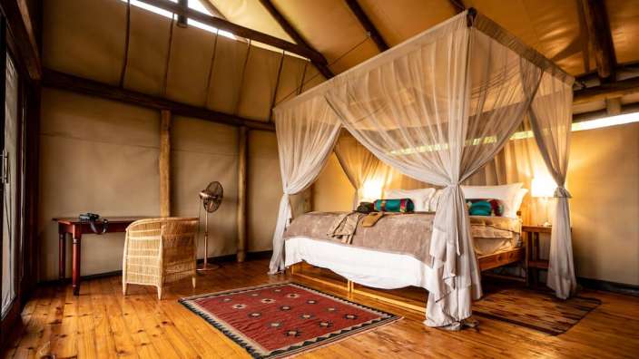 Ein Schlafzimmer mit einem Himmelbett und einem roten Teppich