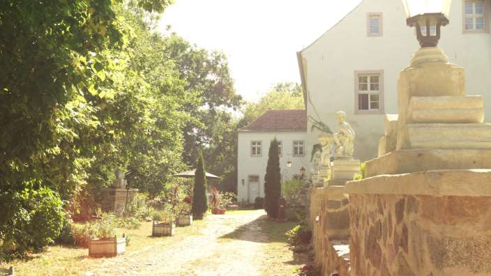 Ein weißes Gebäude mit einer Statue davor