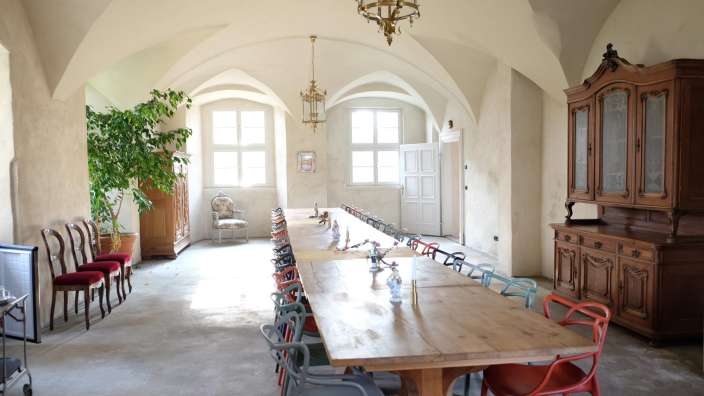 Ein langes Holztisch und viele Stühle in einem Raum