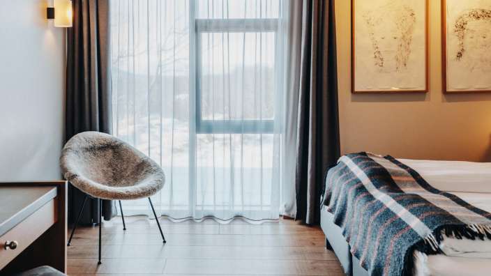 Ein Hotelzimmer mit zwei Betten und einem Stuhl