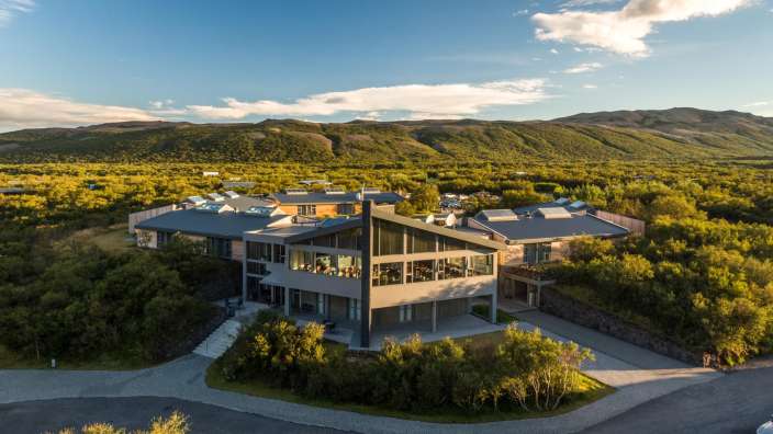 Ein großes Haus steht auf einem Hügel mit Blick auf die Berge
