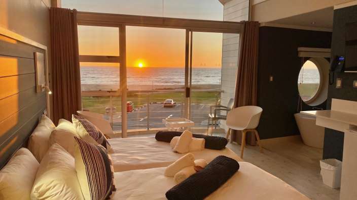Ein Hotelzimmer mit Blick auf das Meer bei Sonnenuntergang