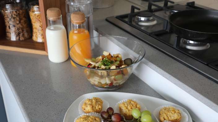 Eine Küche mit einem Teller mit Cupcakes und einer Schüssel Obstsalat