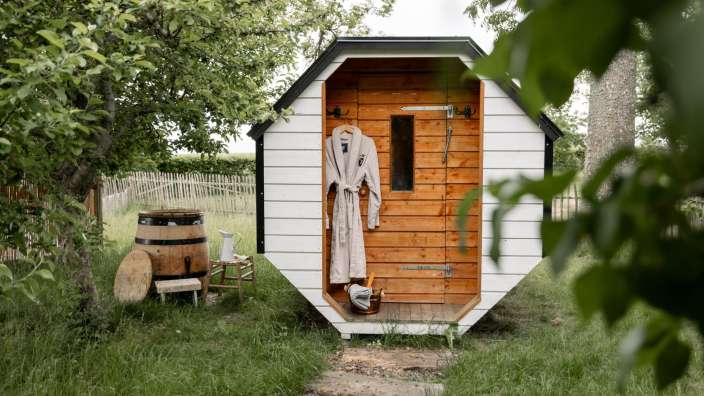 Ein Bademantel hängt an der Tür eines kleinen Holzhauses