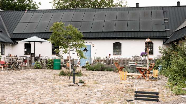 Ein weißes Gebäude mit einem schwarzen Dach und einer blauen Tür