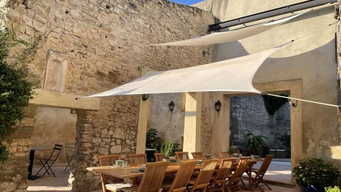 Ein Tisch und Stühle unter einem weißen Sonnenschirm