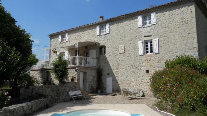 Ein großes Steinhaus mit einem Pool davor