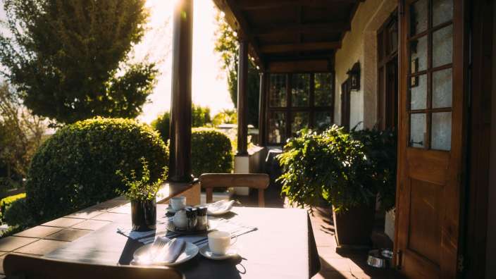 Ein Tisch mit Tellern und Tassen auf einer Veranda