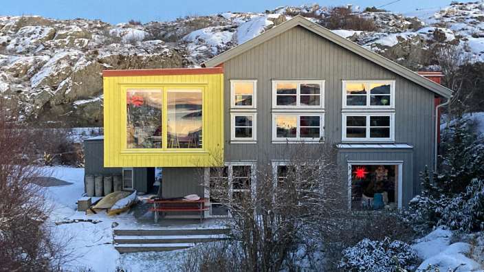 Ein graues und gelbes Haus mit vielen Fenstern