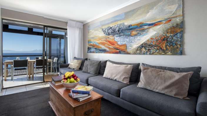 Ein Wohnzimmer mit einer Couch und einem Gemälde an der Wand