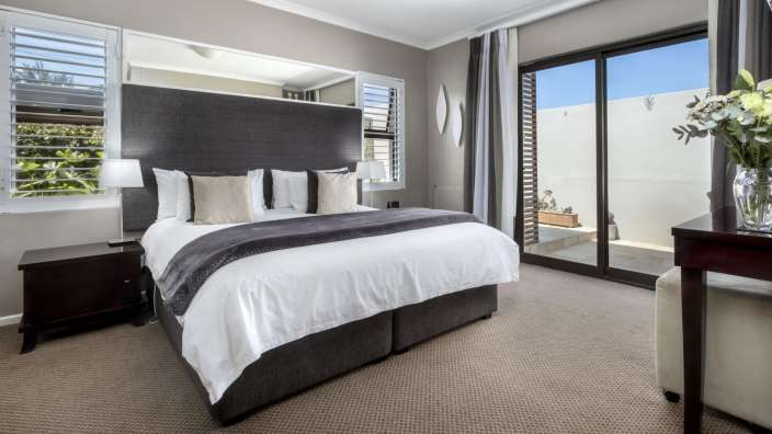 Ein Schlafzimmer mit einem großen Bett und einer Glasschiebetür