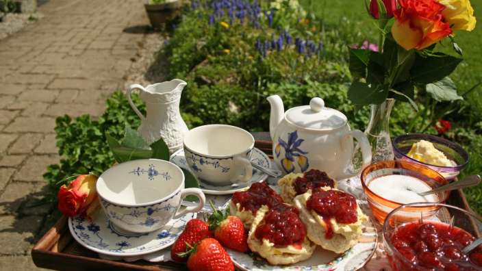 Ein Tablett mit Scones und Erdbeeren darauf