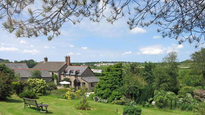 Eine Bank sitzt auf einem Rasen in der Nähe eines Hauses