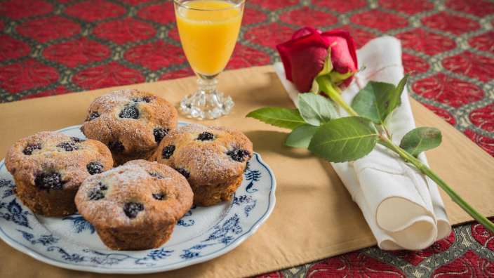 Ein Teller mit Muffins und ein Glas Orangensaft