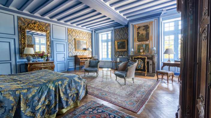 Ein Schlafzimmer mit blauen Wänden und einem blauen Bett