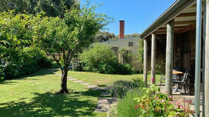 Ein Haus mit einem Tisch und Stühlen auf der Veranda