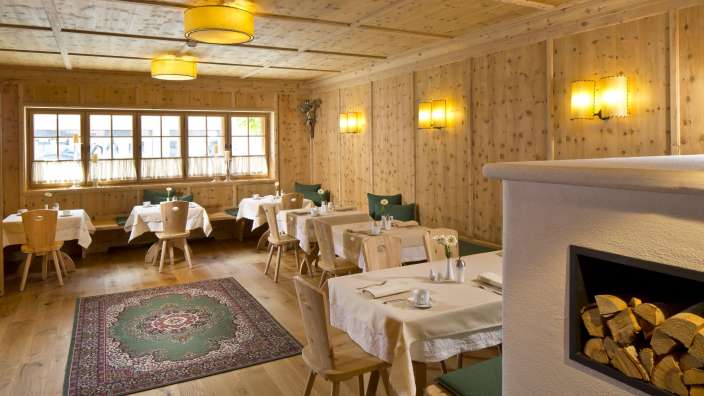 Ein Esszimmer mit Holzwänden und Tischen und Stühlen